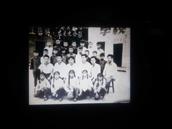 坝孜村 四十多年前坝孜小学毕业生与教师合影照，背景为当时的老教舍