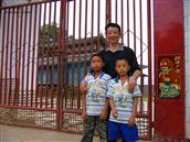 曼晃村 照片后的傣族庄房是我们当年28个知青住地，2005年5月我来到蛮英寨子和寨子里的孩子合影！